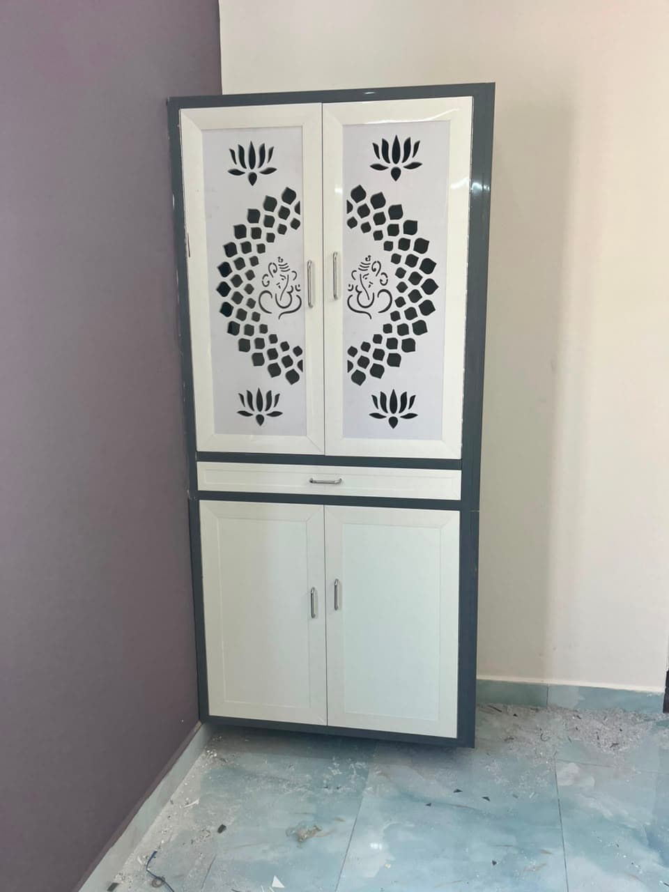 Custom pooja cabinet with Ganesha motif glass doors and storage drawers