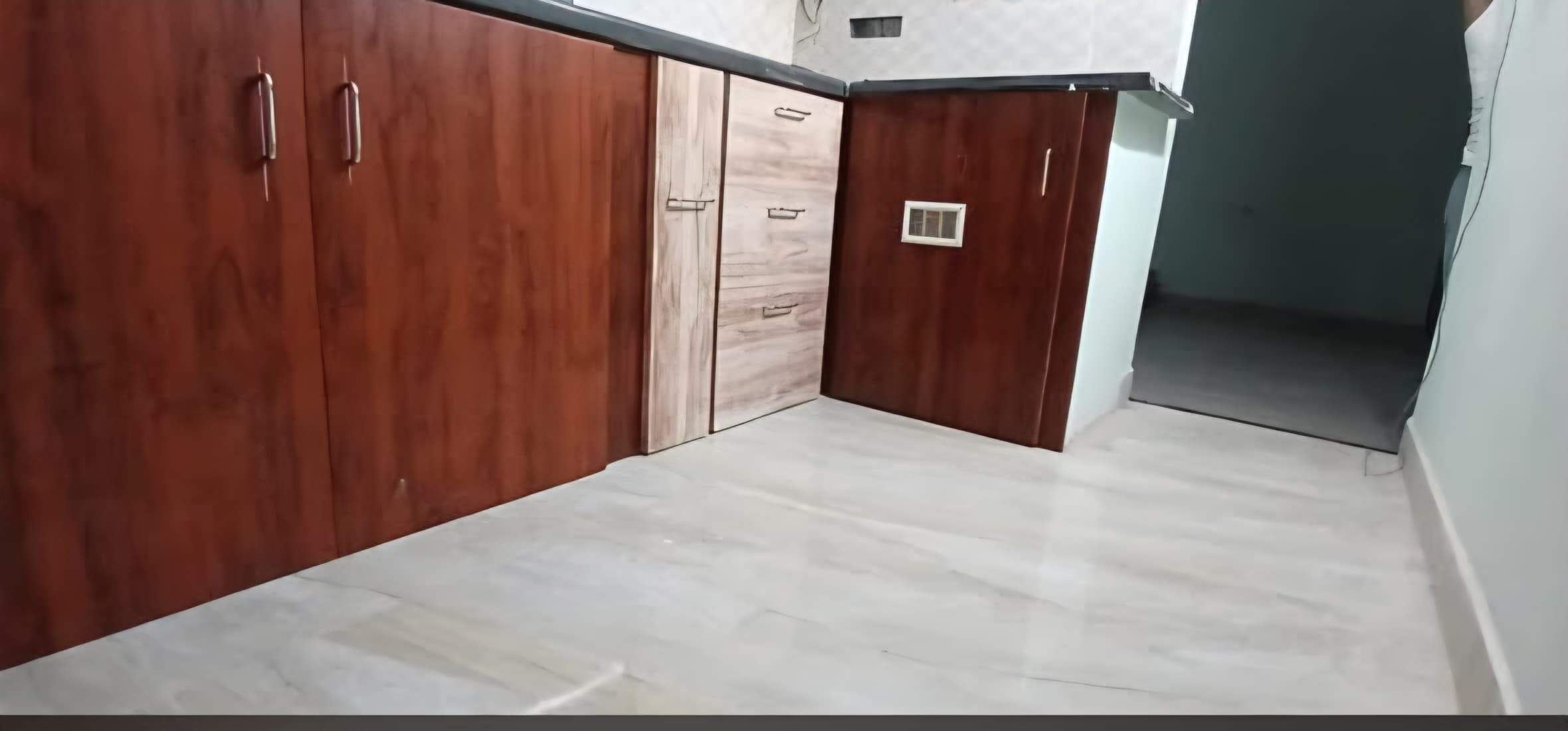 Two-tone modular kitchen base cabinets with wood-grain laminate finish