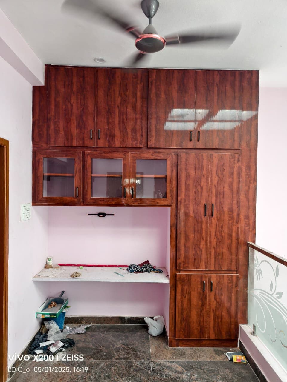 Built-in study desk with overhead glass cabinets and wardrobe storage